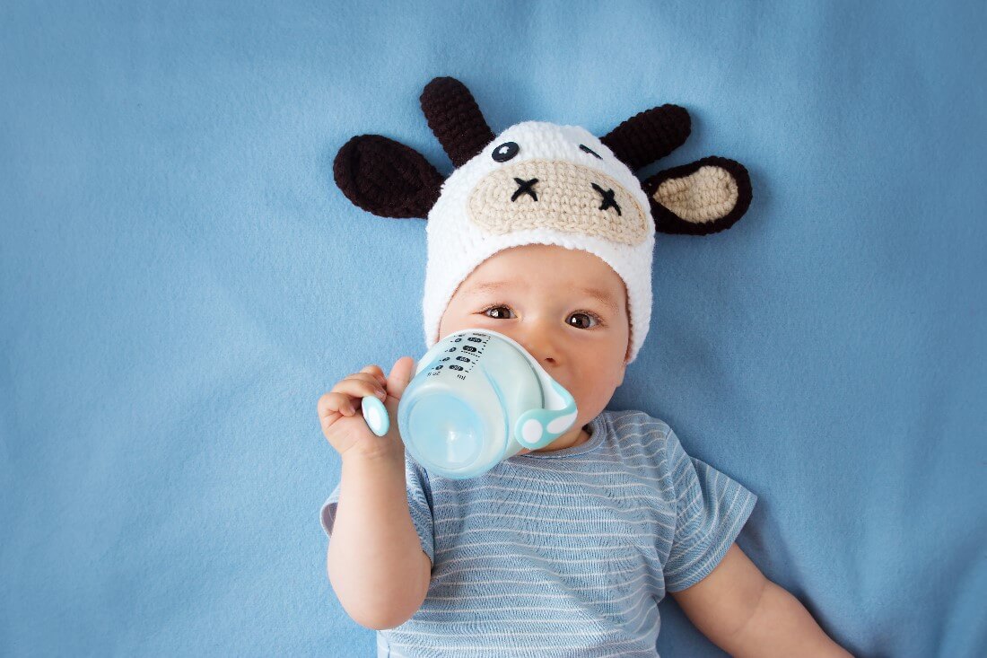 cute baby in a cow hat drinking milk - Baby Bottle Tooth Decay